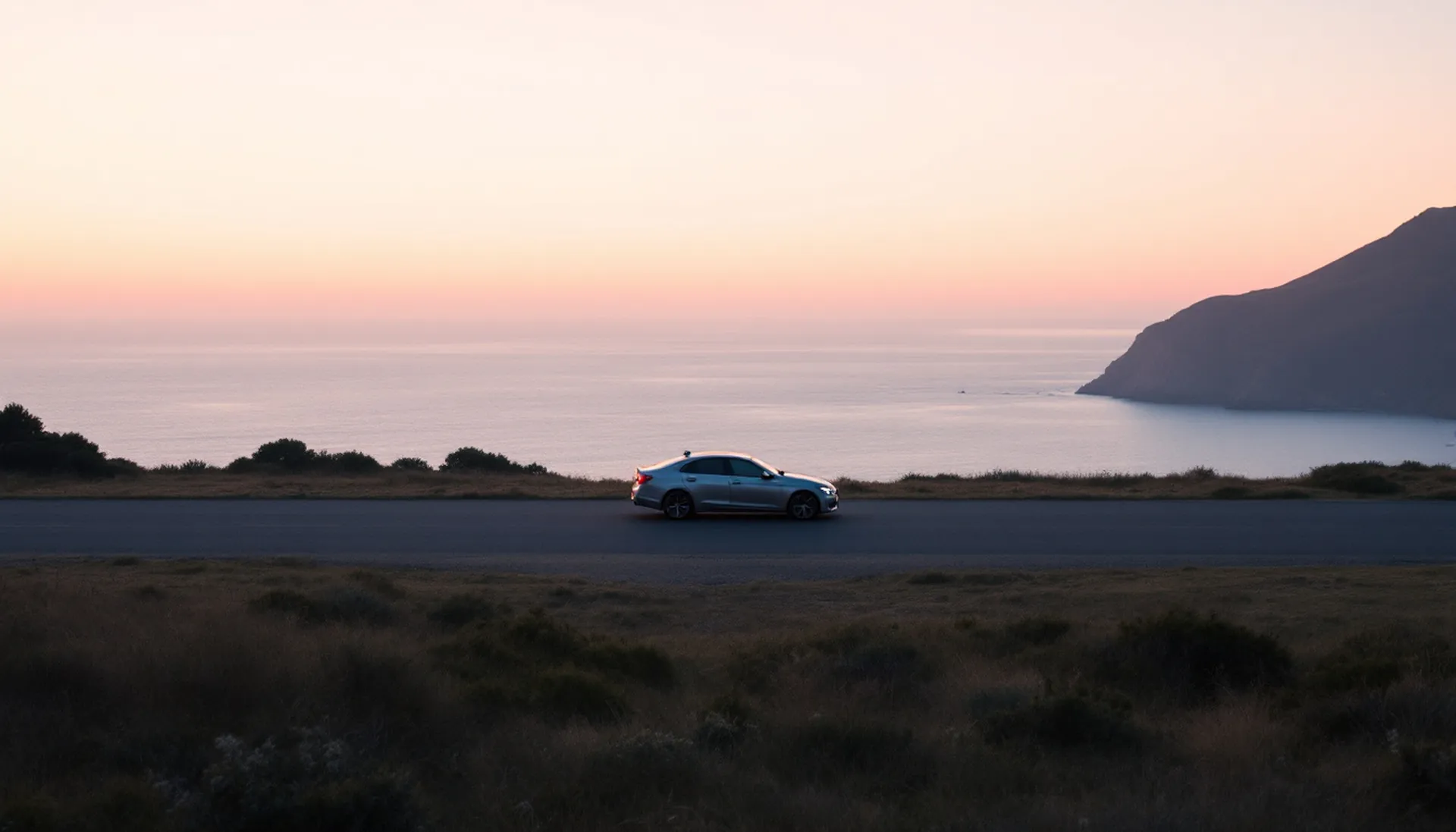 A single sedan parked at a quiet coastal overlook at dawn facing a calm sea, SedanPolicy personal loan requests $100 to $5,000